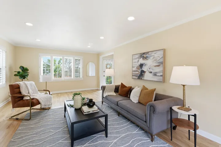 Bright living area featuring light wood-finish flooring, recessed lighting, and crown molding