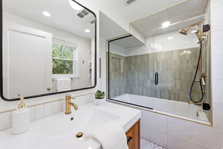 Contemporary bathroom featuring a vanity with an integrated sink, gold-tone faucet, and an undermount wood-finish cabinet