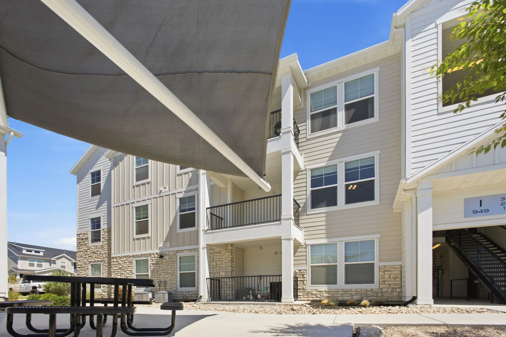 Multi-story exterior featuring light-toned siding and stone veneer accents