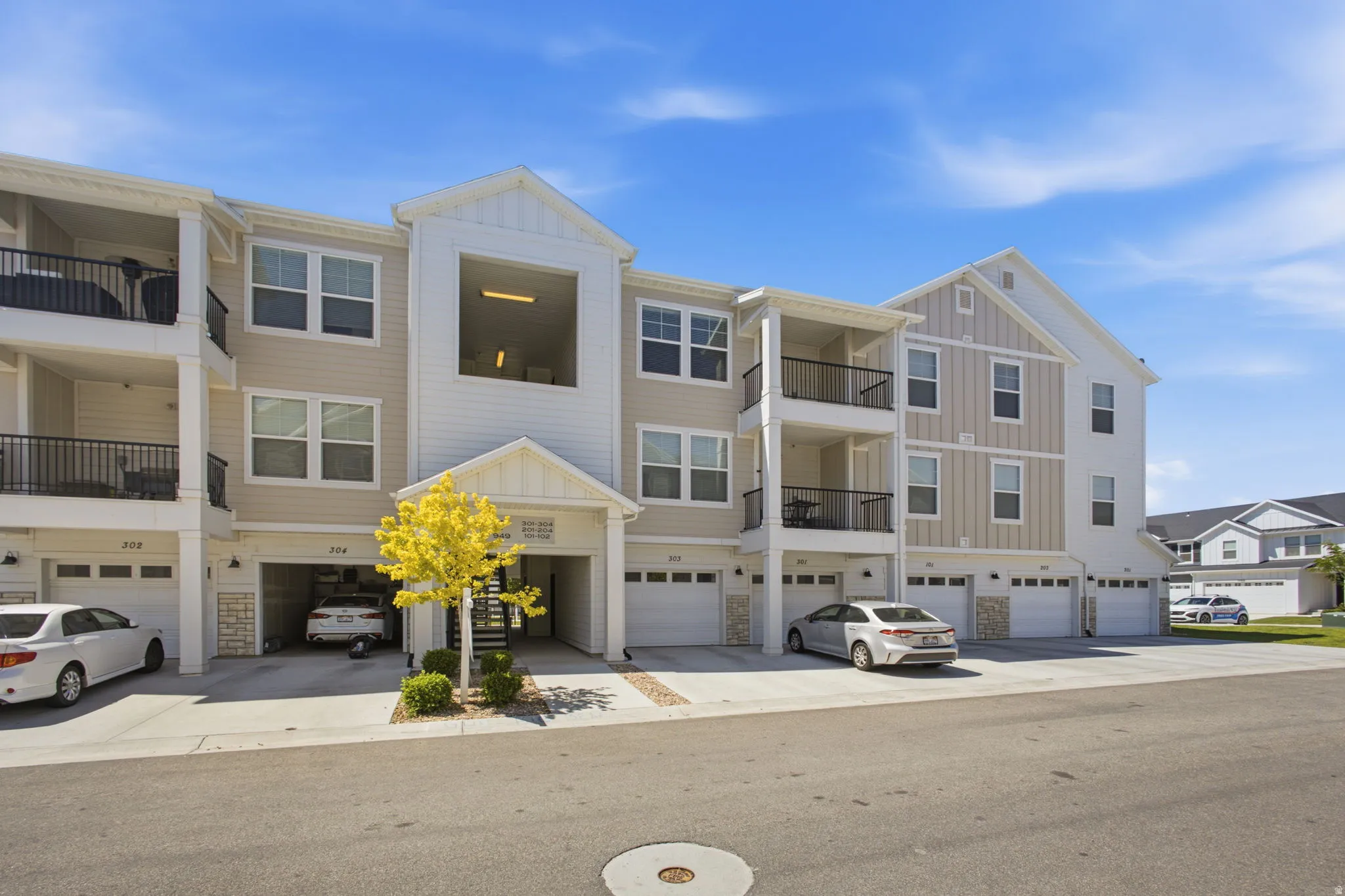 Modern multi-story building featuring light-colored siding and white trim accents