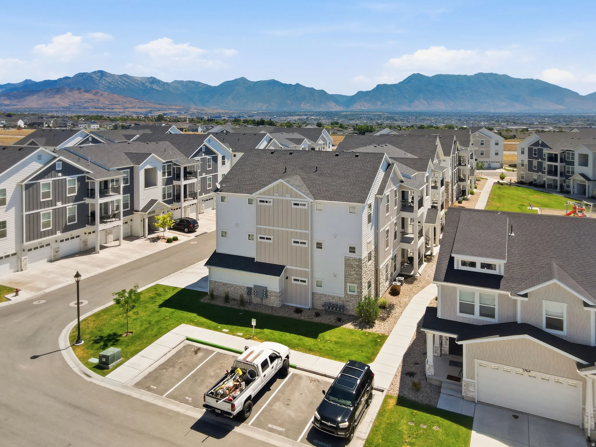 Residential community featuring multi-story buildings with varied siding, private balconies, and attached garages