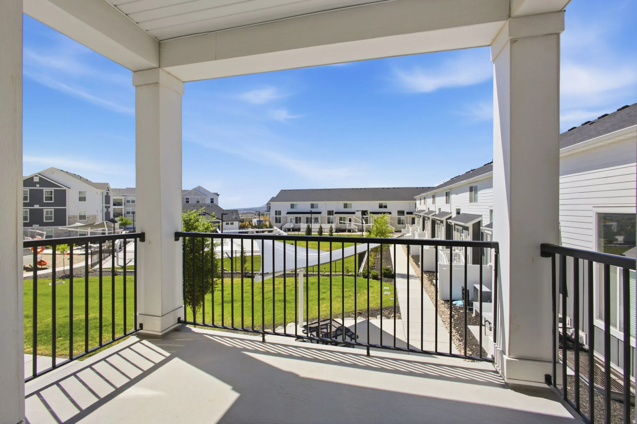 Spacious balcony featuring a concrete surface and black metal railings