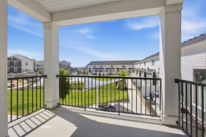 Spacious balcony featuring a concrete surface and black metal railings
