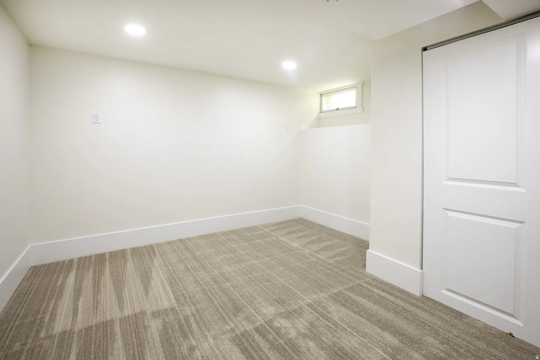 Neutral wall finishes with a light-colored carpet featuring a linear pattern