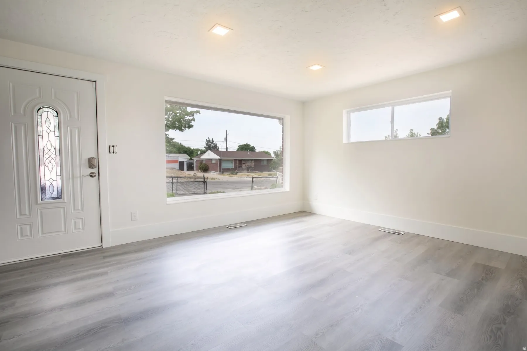 Bright living space featuring wood-finish flooring, white walls, and recessed lighting