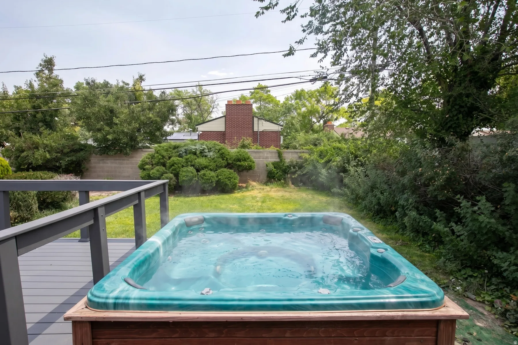 Hot tub with a wood-finish surround on a composite deck