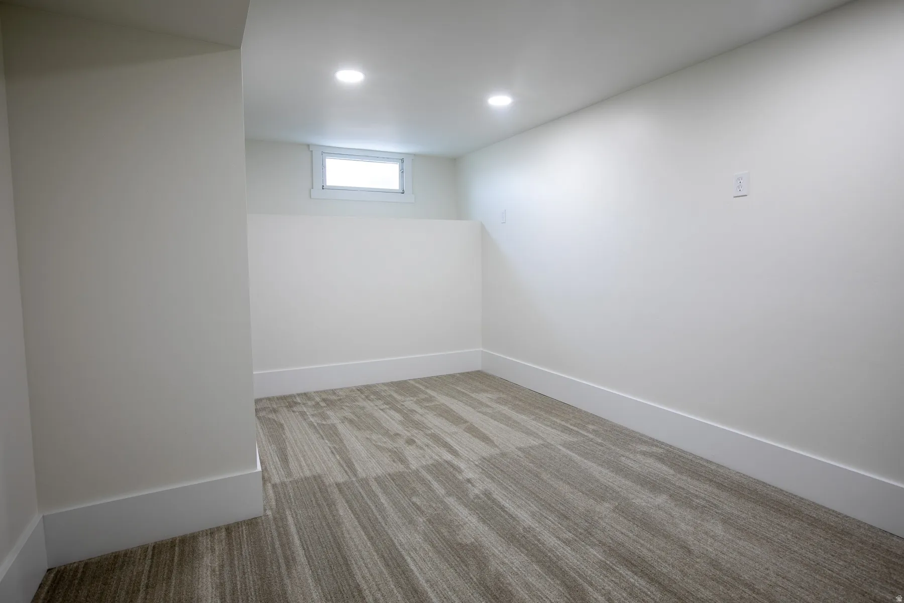 Room featuring patterned carpet flooring, recessed lighting, and a single window with white trim