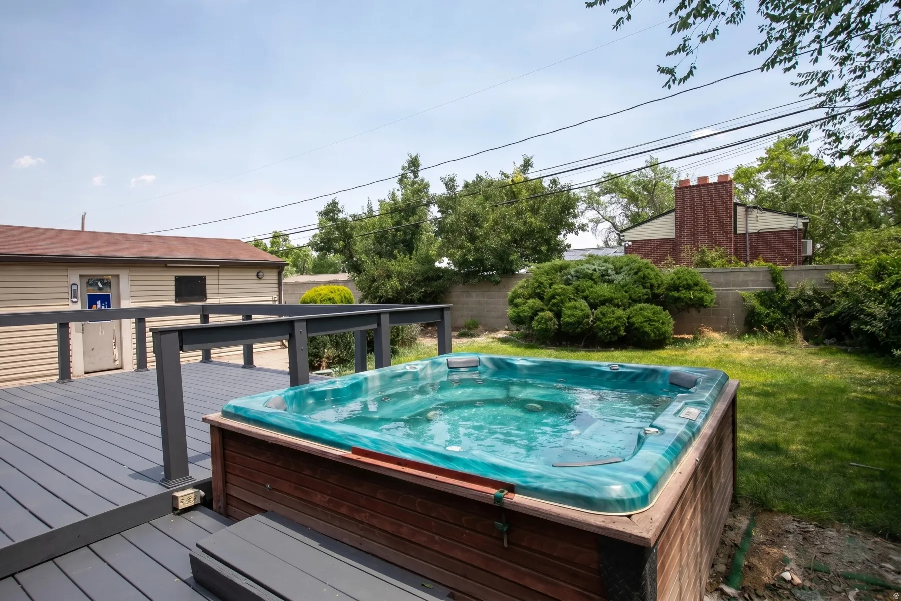 Deck with built-in spa, dark gray composite decking, and dark gray railings