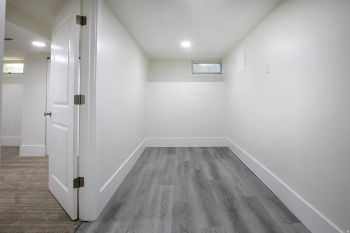 Interior room featuring light gray wood-finish flooring, white painted walls, and white baseboards