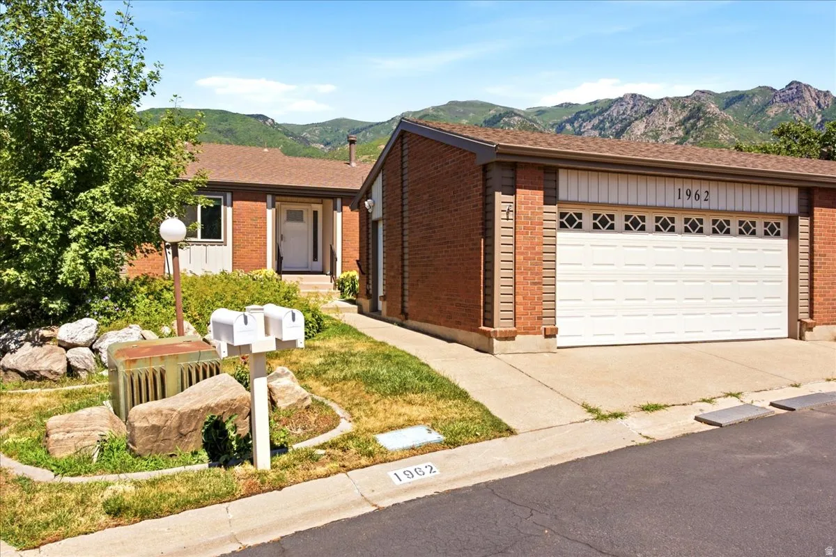 Brick facade residence featuring an attached two-car garage with decorative window inserts
