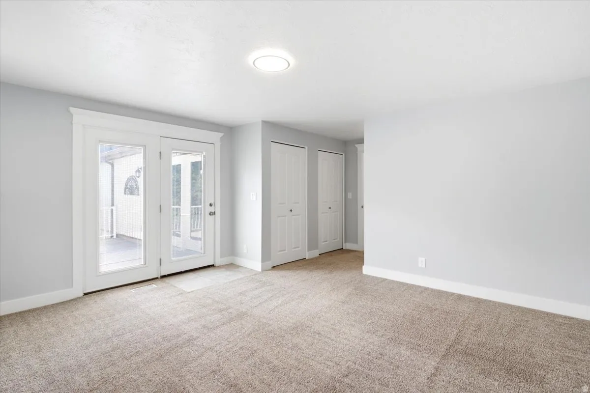 Room featuring light gray painted walls and neutral-toned carpeting