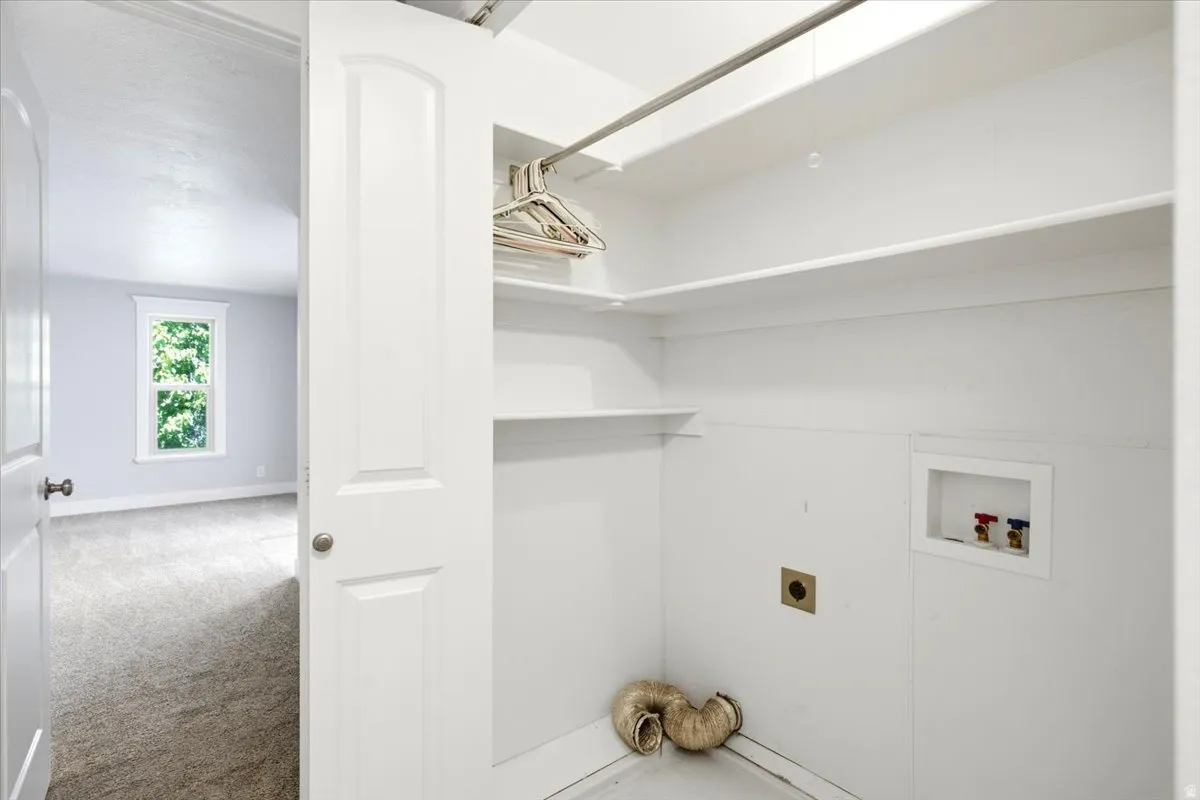 Dedicated laundry area with utility hookups and built-in shelving