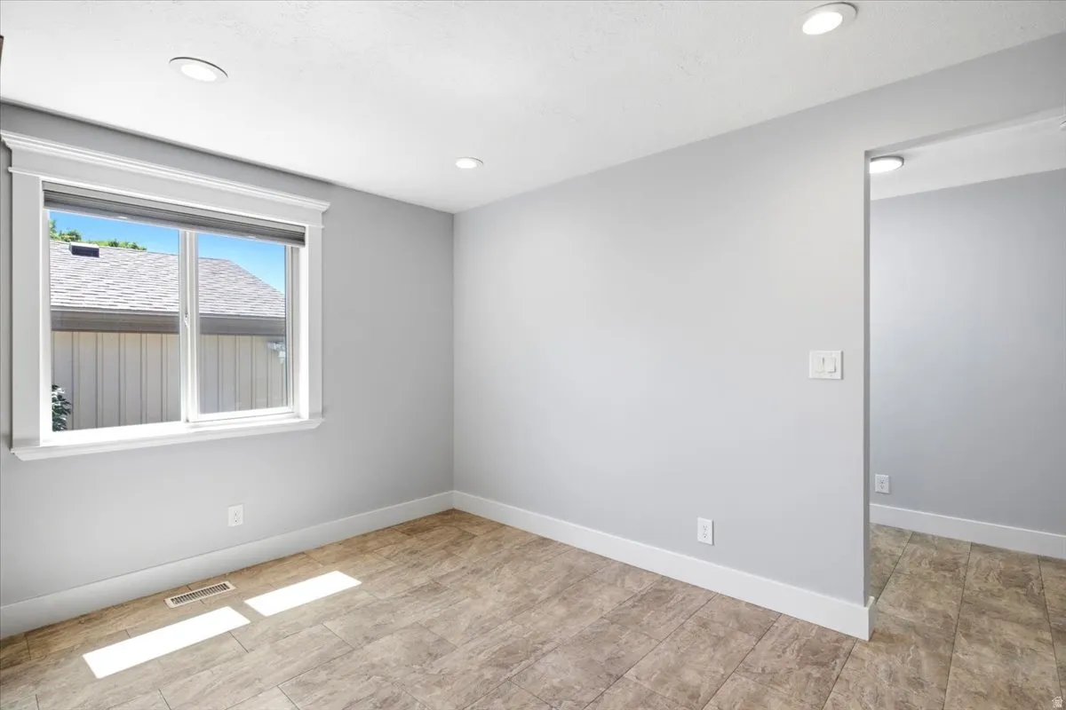 Room featuring recessed lighting, a single window with white trim, and light gray wall paint
