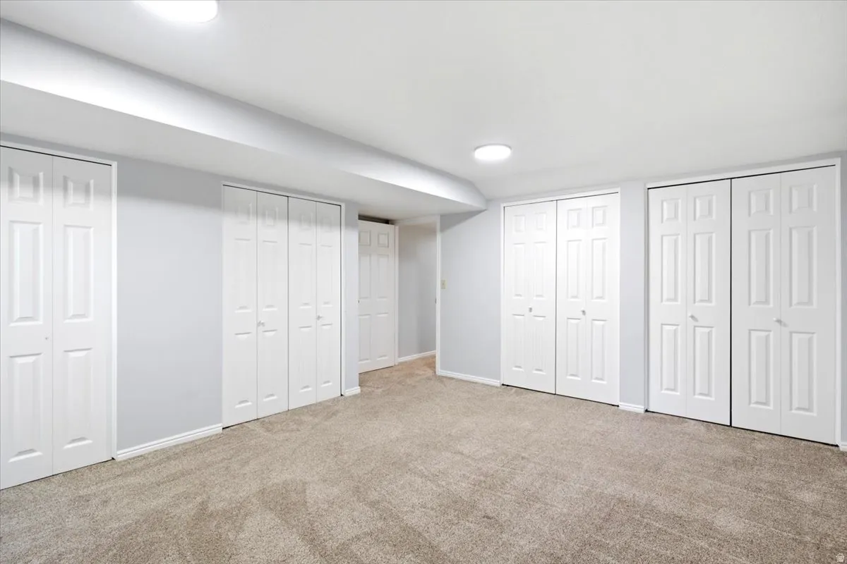 Finished interior space featuring light gray walls, white trim, and neutral carpet flooring