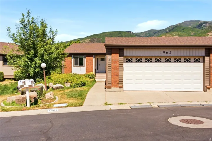 Brick facade with a white garage door featuring decorative window inserts