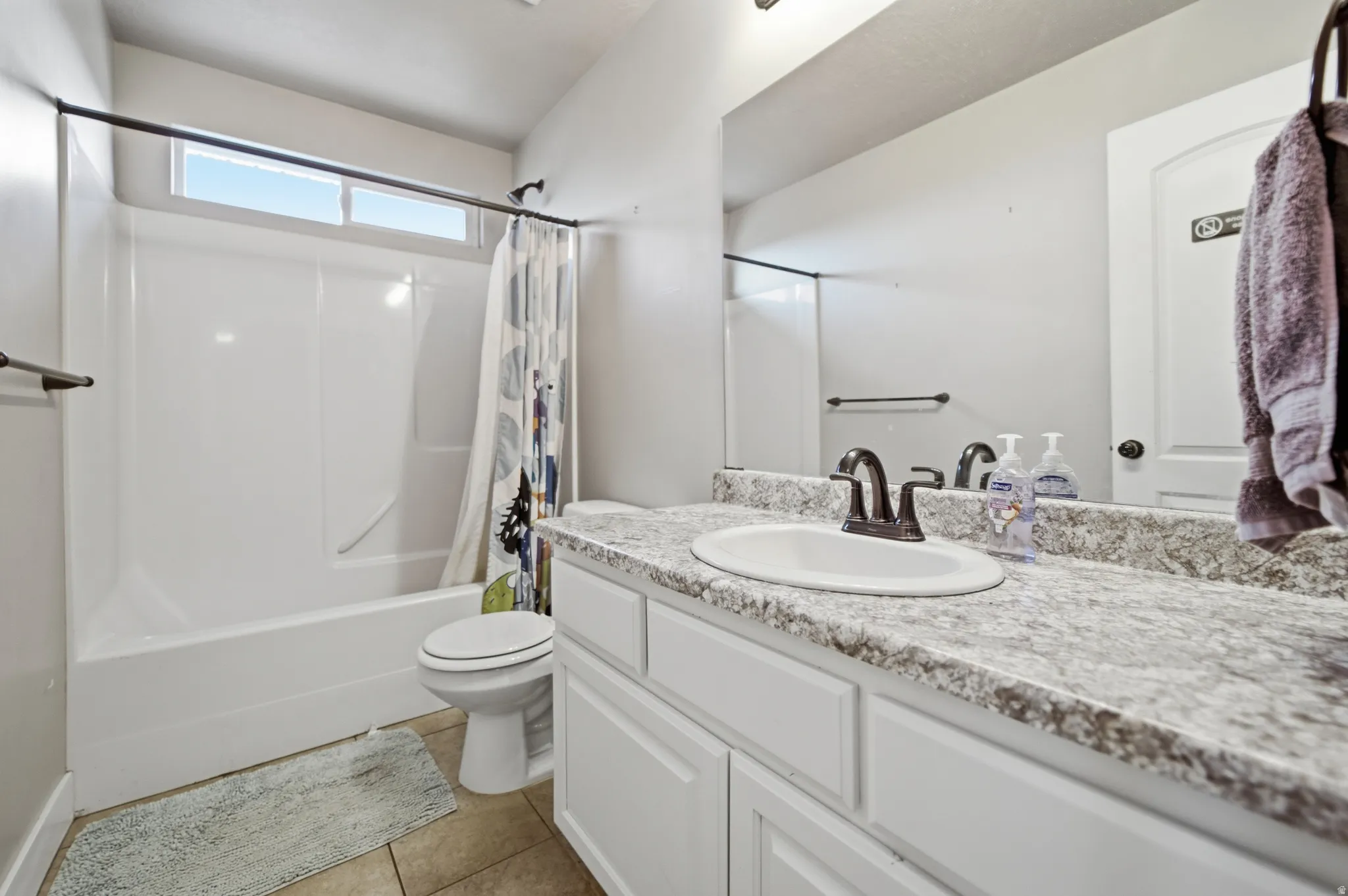 Full-width vanity mirror, integrated sink, and white cabinetry