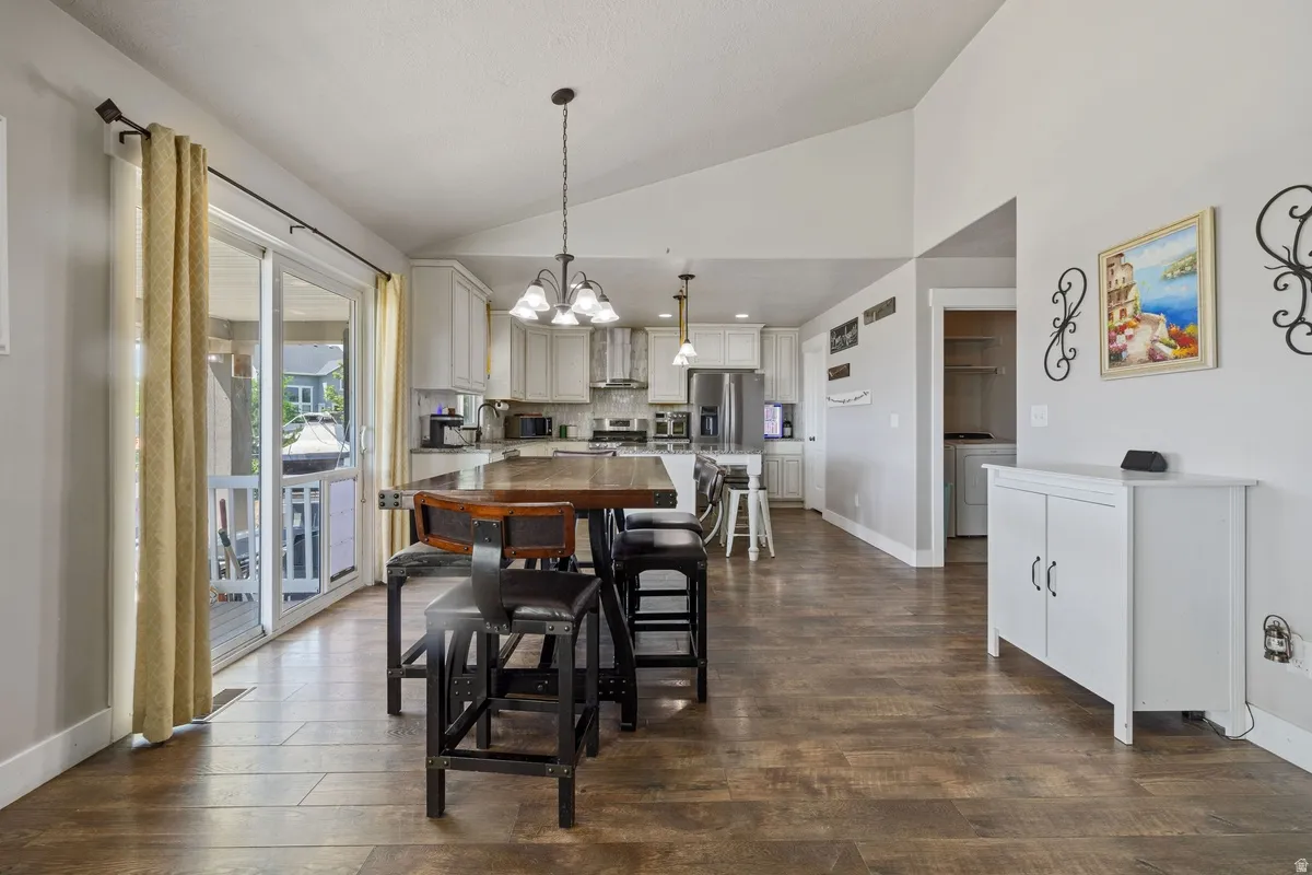 Open-concept living space featuring wood-finish flooring and vaulted ceilings