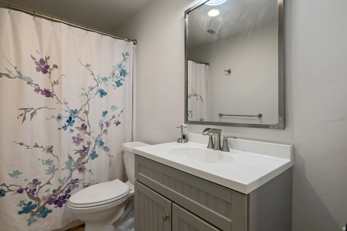 Bathroom vanity featuring a white countertop with an integrated sink and a brushed nickel faucet