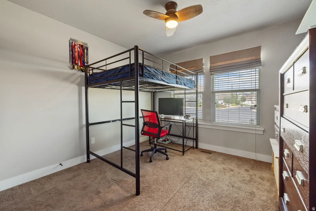 Carpeted room with multiple windows providing natural light