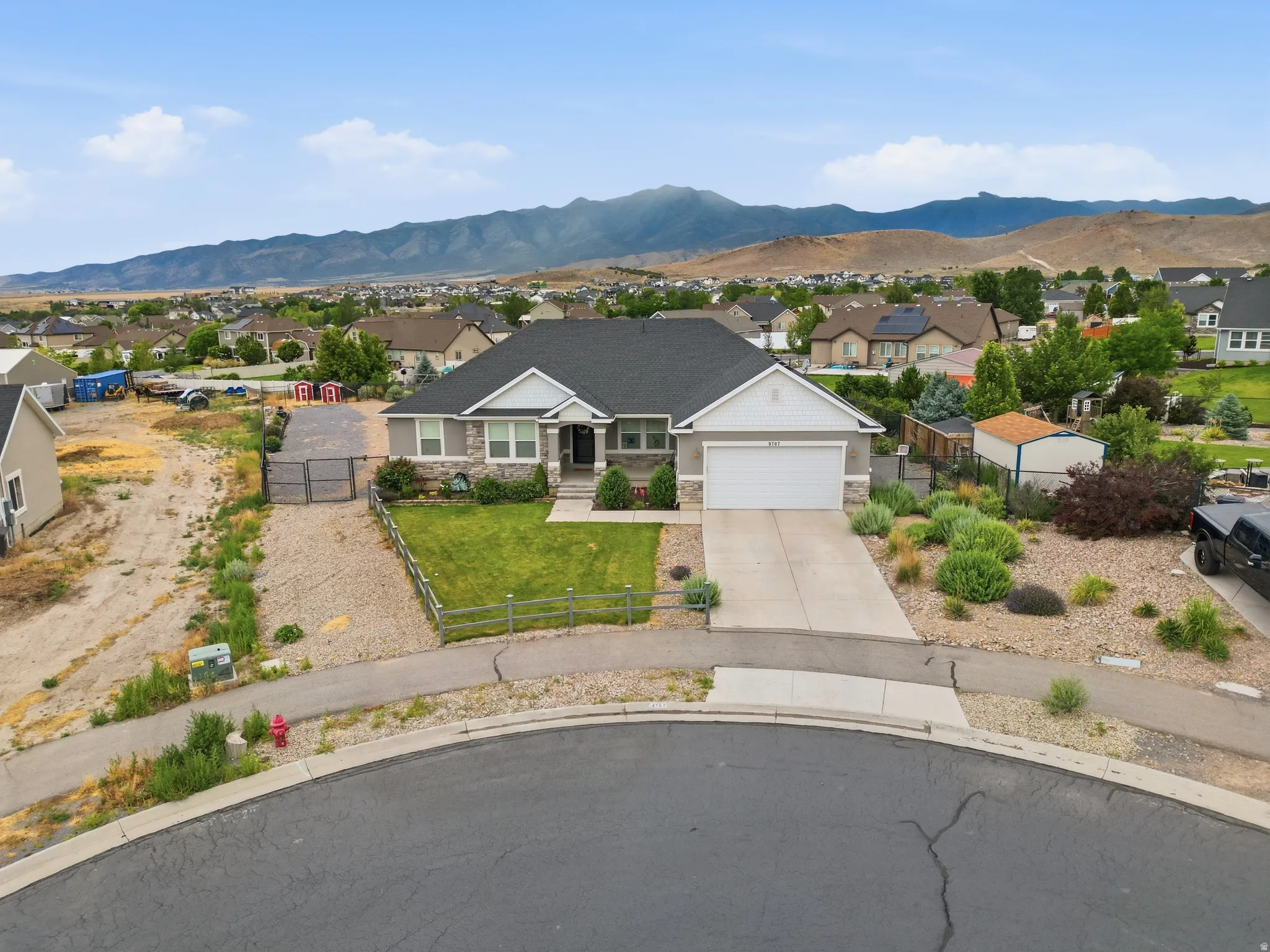 Ranch-style residence featuring a stone and siding exterior, an attached two-car garage, and a concrete driveway