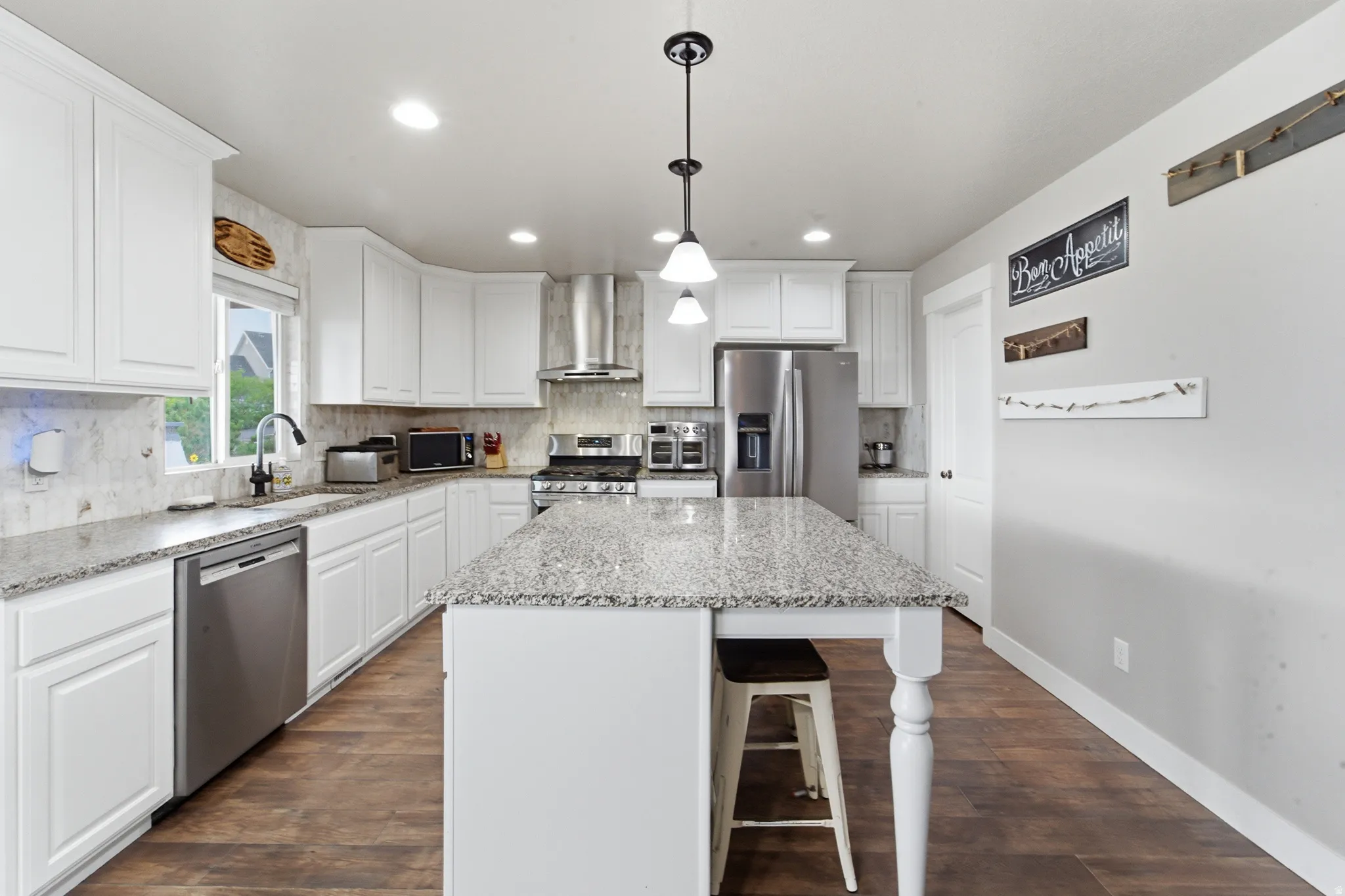 Kitchen featuring white cabinetry, wood-finish flooring, recessed lighting, and a center island with a speckled countertop