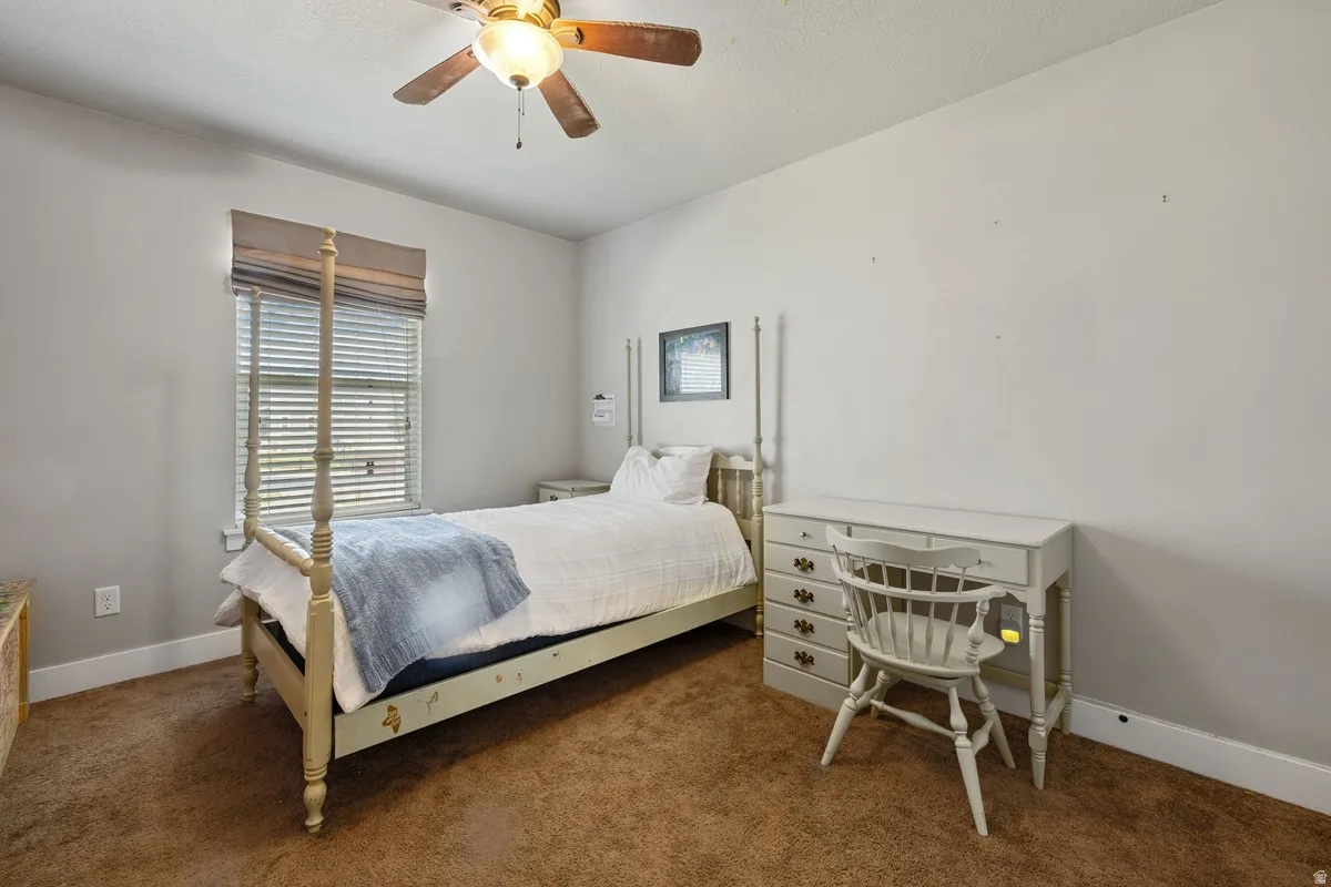 Carpeted room with a ceiling fan