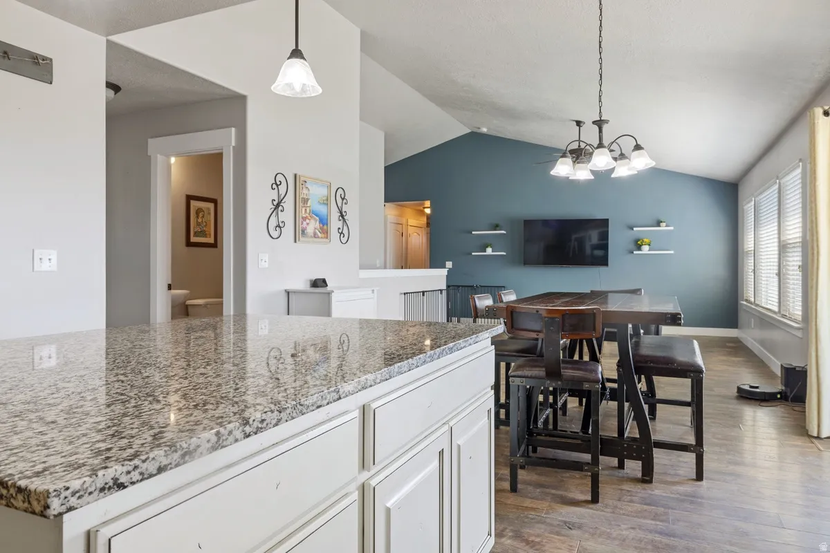 Kitchen island with a granite-style countertop and light-toned cabinetry