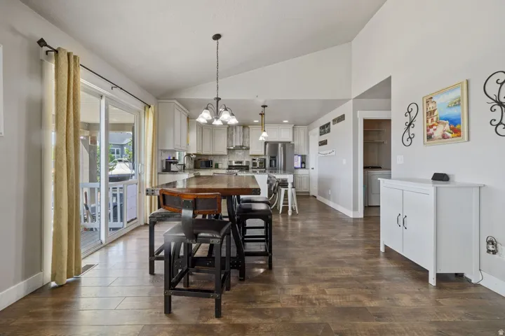 Open-concept living space featuring wood-finish flooring and vaulted ceilings