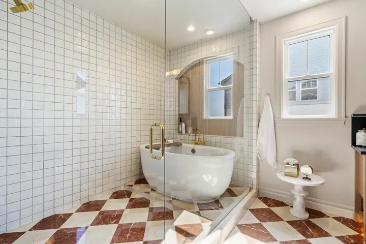 Spacious walk-in shower with clear glass enclosure and overhead shower fixture