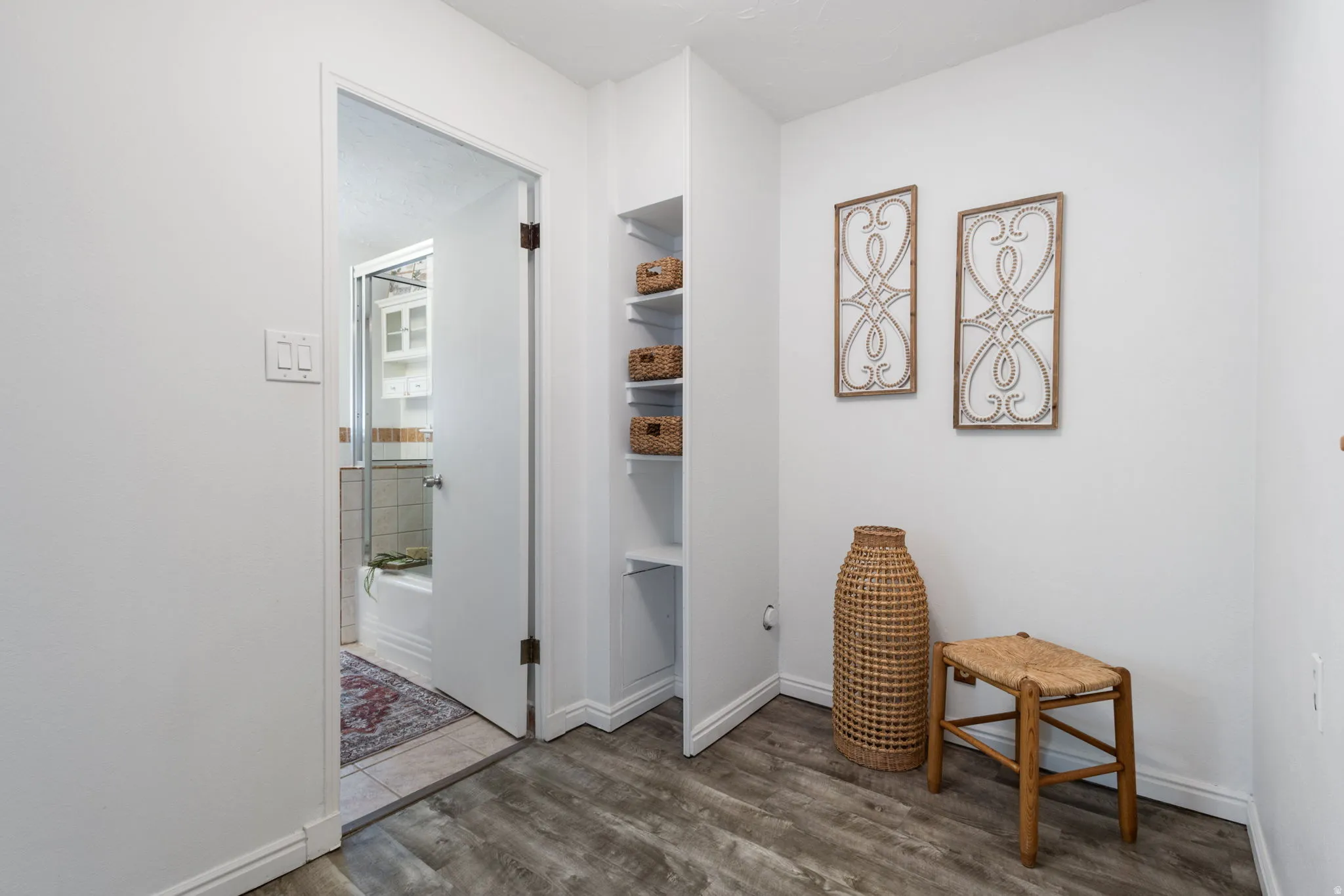 Hallway featuring wood-finish flooring and integrated shelving