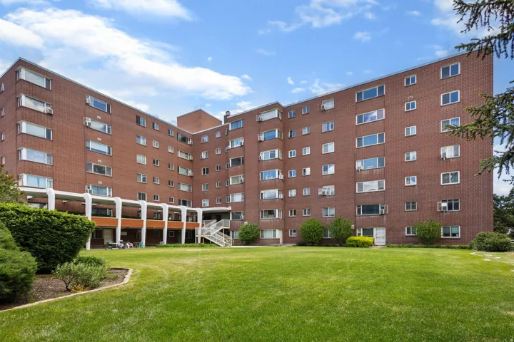 Expansive green lawn fronting a multi-story brick building