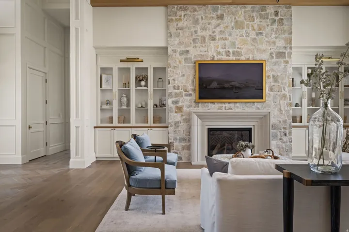Stone fireplace featuring a classic mantel, hearth, and firebox with iron grate