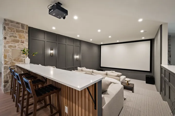 Dedicated media room featuring a large projection screen and ceiling-mounted projector