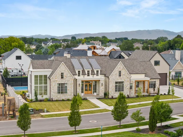 Contemporary residence featuring a stone and stucco exterior, prominent gables, and solar panels