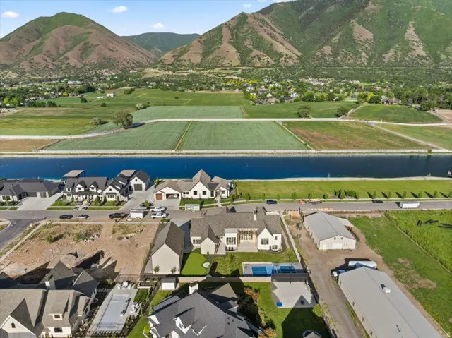 Expansive aerial showcasing a modern residence with a private swimming pool, surrounded by manicured green space