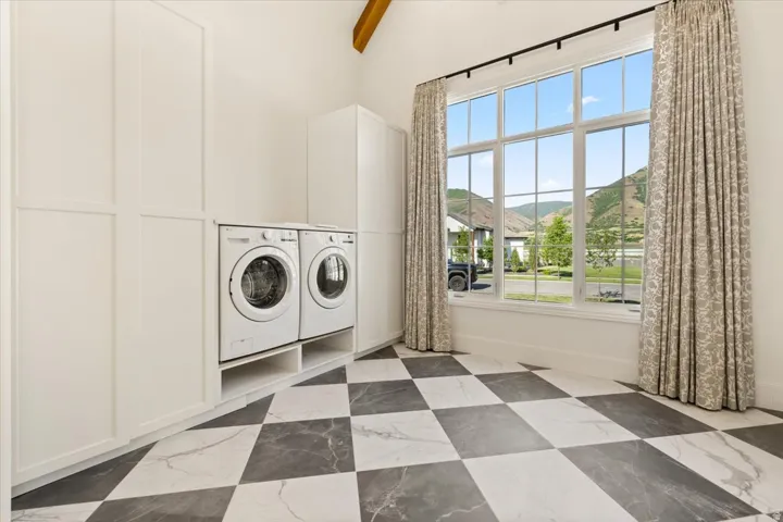 Spacious utility room featuring checkerboard tile flooring and built-in white cabinetry