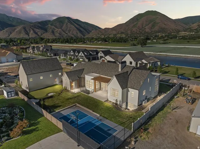 Contemporary residence featuring a light-colored exterior and dark-shingle roofing