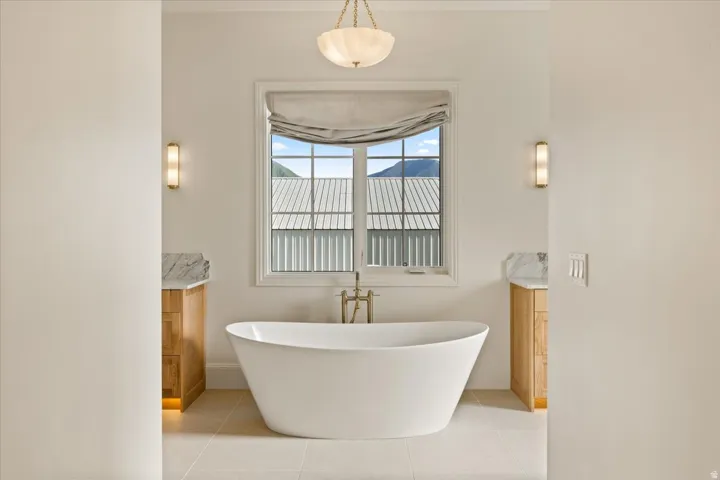 Freestanding soaking tub centered under a large window