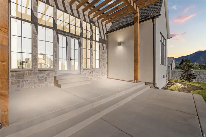 Expansive concrete patio with integrated steps leading to French doors