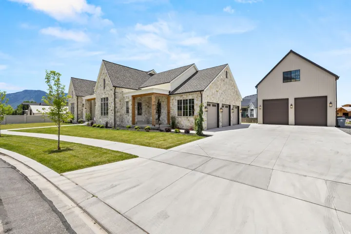 Stone facade residence with a multi-car attached garage and a detached multi-car garage structure