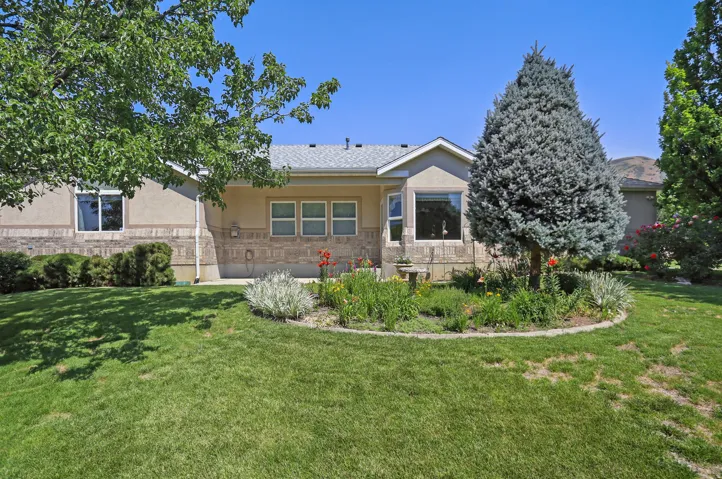 Rear exterior featuring a bay window, stucco siding, and stone accents