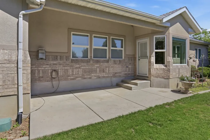 Concrete patio area with a stucco and stone veneer exterior