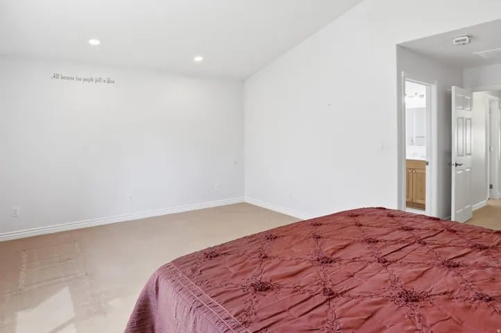 Carpeted room featuring a vaulted ceiling with recessed lighting