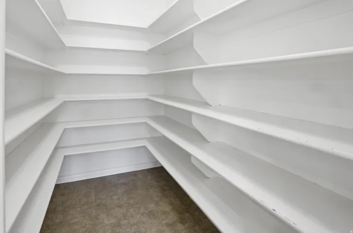 Walk-in pantry with ample white shelving