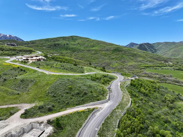 Expansive mountain landscape featuring paved roads and several structures
