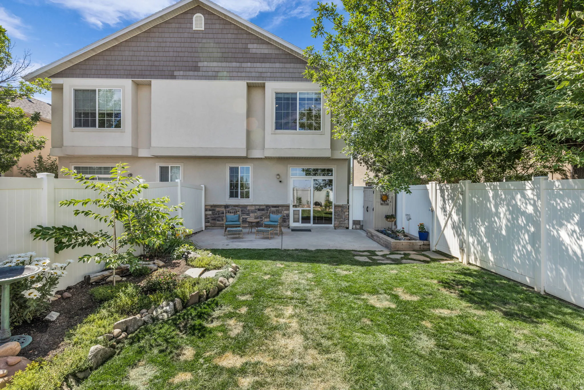 Expansive lawn area with a landscaped rock garden and mature trees
