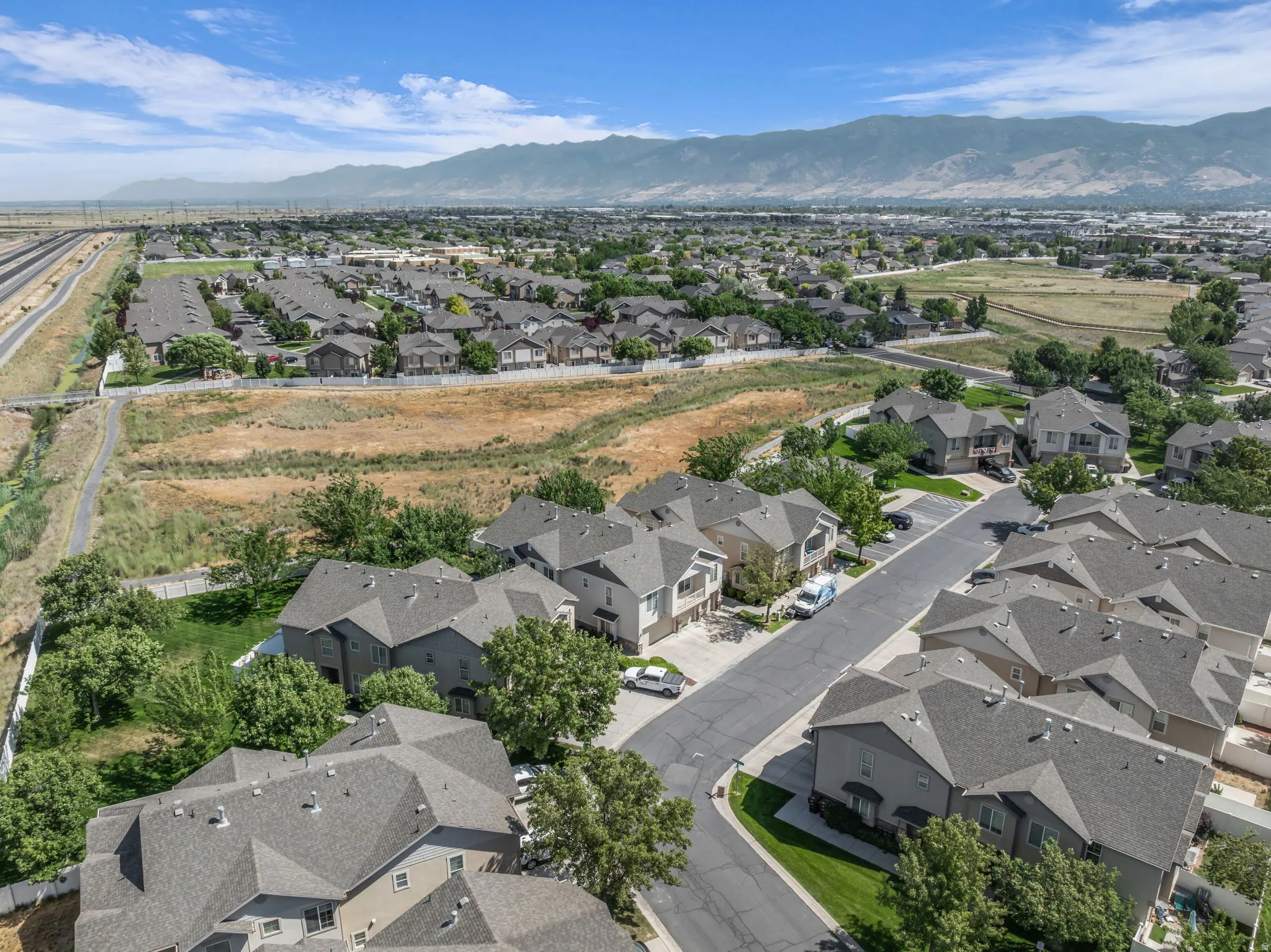 Aerial perspective showcasing a residential community with varied rooflines and surrounding green spaces