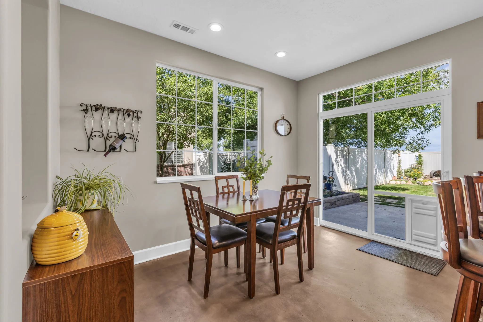 Dining area featuring a large window, sliding glass door, recessed lighting, and wood-finish flooring
