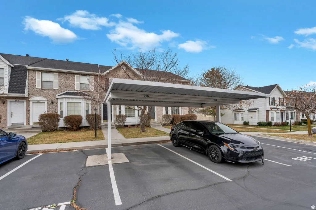 Assigned covered parking space featuring a metal canopy and defined white parking lines