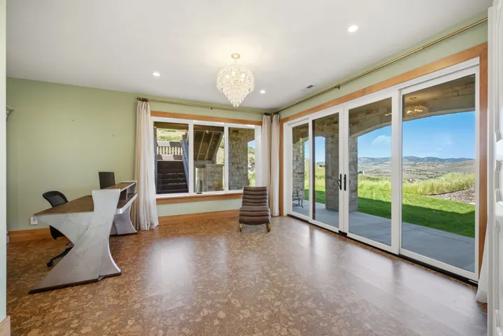 Spacious room featuring cork flooring, a crystal chandelier, and recessed lighting